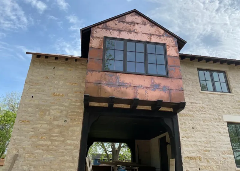 Copper metal panel facade on a stone building for Skylight Installation in Town of Pecos